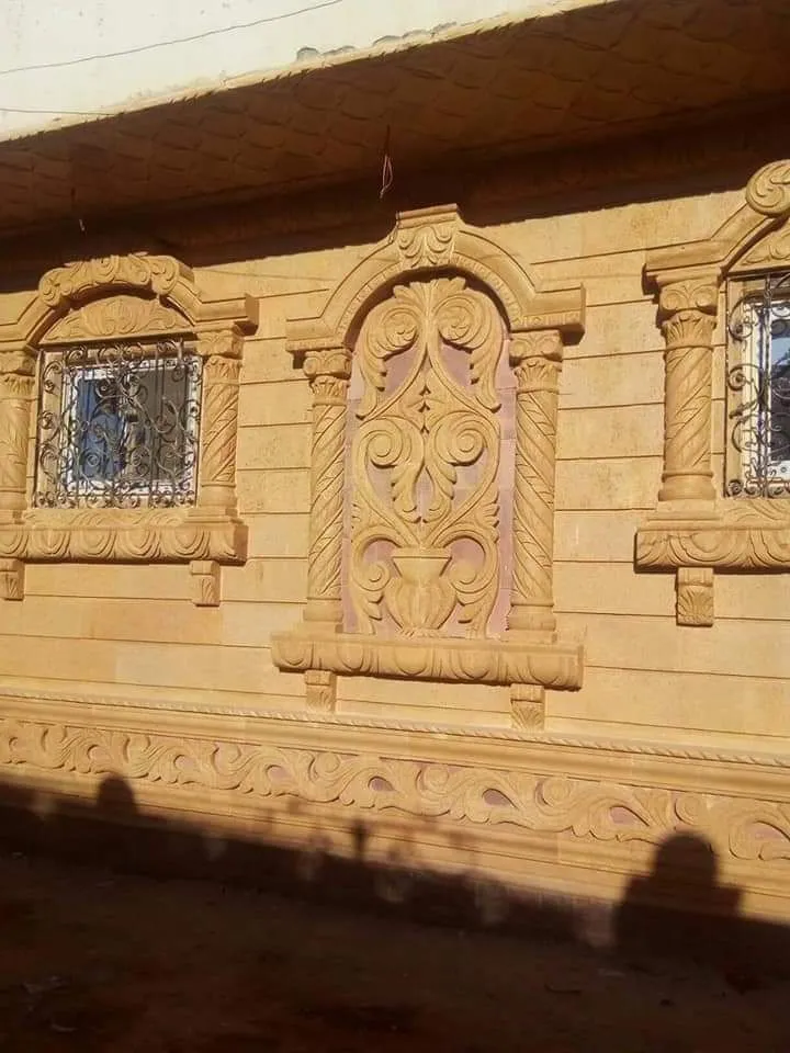 حائط من الحجر الهاشمي بتابلوه منحوت وشبابيك بأعمدة مبرومة