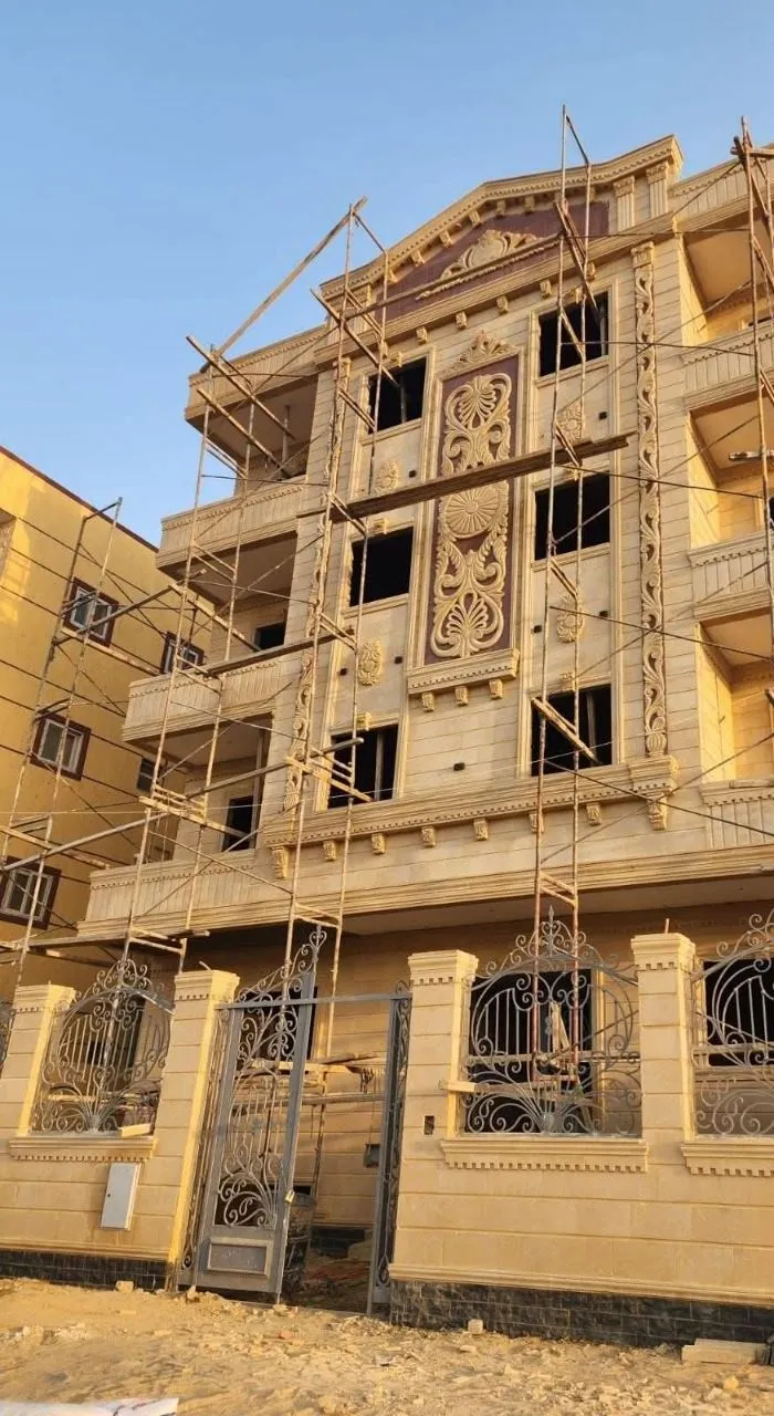 واجهة عمارة من الحجر الهاشمي بلوحة زخرفية وتاج مثلث، قيد التنفيذ
